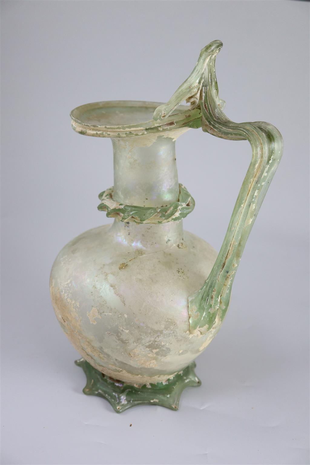 A good Roman olive green glass ewer or pitcher, Eastern Mediterranean, 3rd/4th century AD, 32cm high